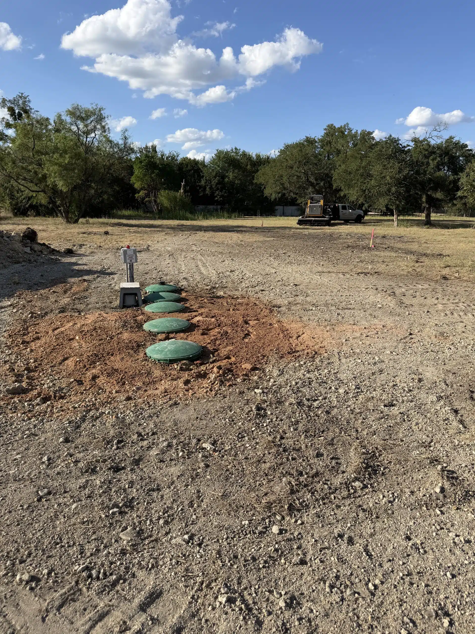 Completed septic tank installation with a clean tank cover blending into a well-kept green lawn and finished landscaping